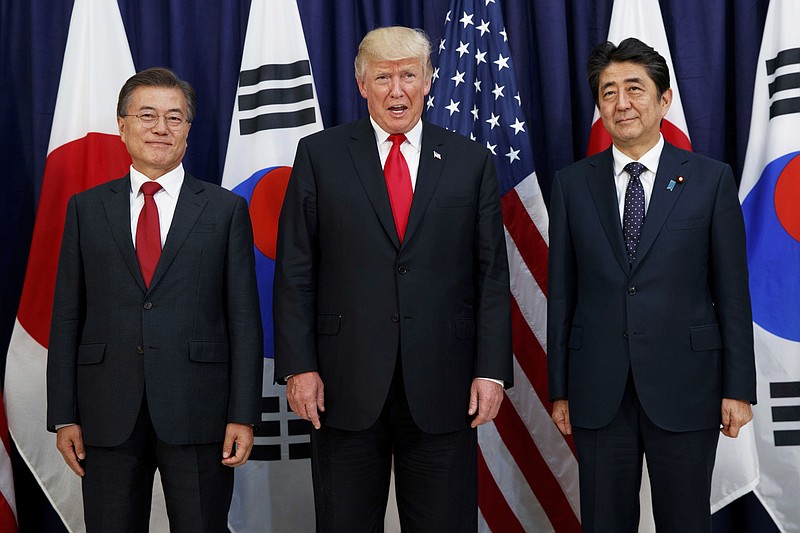 In this July 6, 2017, file photo, U.S. President Donald Trump, center, meets with Japanese Prime Minister Shinzo Abe, right, and South Korean President Moon Jae-in before the Northeast Asia Security dinner at the U.S. Consulate General Hamburg in Germany. In August 2019, Trump angered some Asian American voters after the New York Post reported that he mocked the accents of Moon and Abe at a fundraiser in the Hamptons. (AP Photo/Evan Vucci, File)