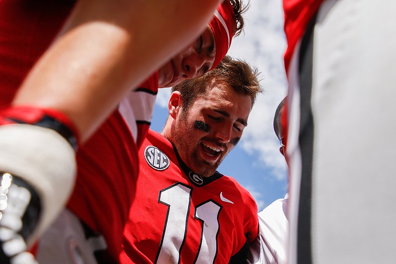 Georgia quarterback Jake Fromm (11) prays among teammates after a home game against MTSU in September 2018.