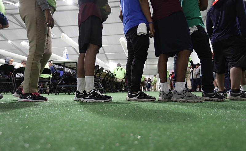Immigrants line up in the dining hall in July at the U.S. government's newest holding center for migrant children in Carrizo Springs, Texas. (AP Photo/Eric Gay, File)