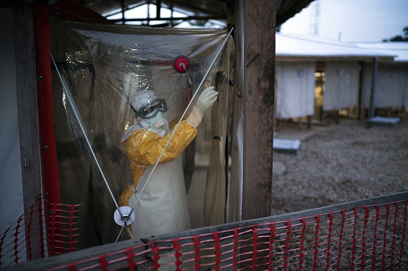 In this Saturday, July 13, 2019, file photo, a health worker wearing protective suits enters an isolation pod to treat a patient at a treatment center in Beni, Congo DRC. The head of Congo's Ebola response says another vaccine will be used to fight the outbreak that has killed more than 1,800 people in a year. (AP Photo/Jerome Delay, File)