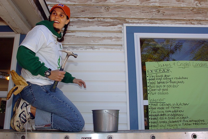 Volunteer Alesha Stam listens to instructions while helping install vinyl siding as part of a Rebuilding Together project to renovate the Springdale, Arkansas, home of James and Crystal Landers. An affiliate of Rebuilding Together, a national nonprofit organization that assists low-income homeowners with repairs, was recently established in Chattanooga. / Photo by Aaron Skinner/Arkansas Democrat-Gazette