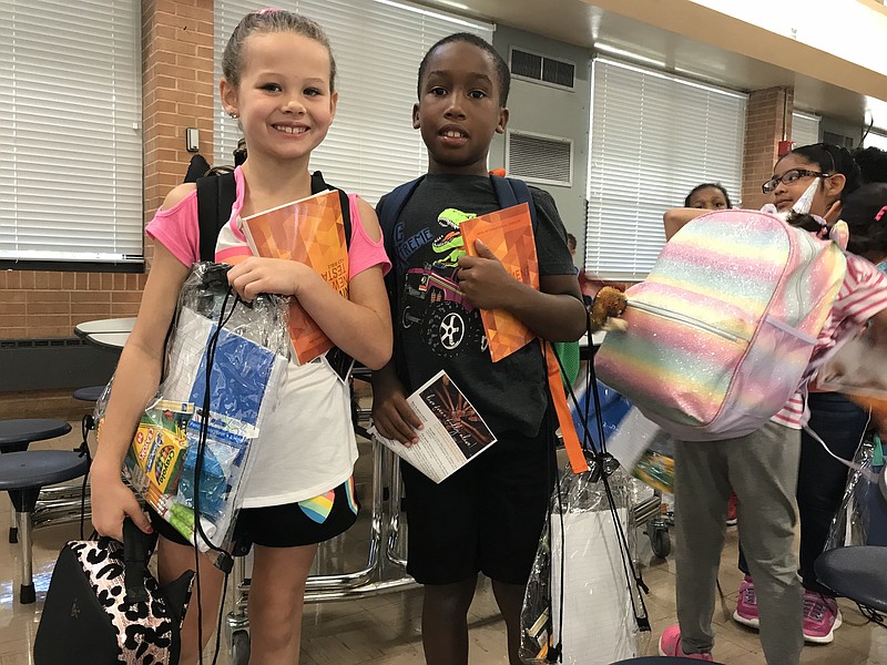 Ayleea Kilgore, left, and Jahki King prepare to head to class with their new school supplies.