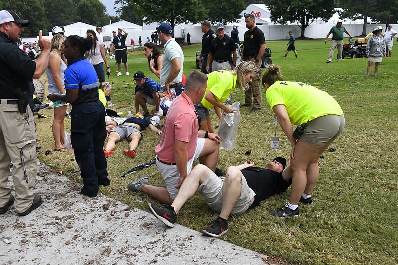 Spectators are tended to after a lightning strike Saturday at East Lake Golf Club injured six people during the suspended third round of the Tour  Championship, the PGA Tour's season finale to decide the winner of the FedEx Cup.