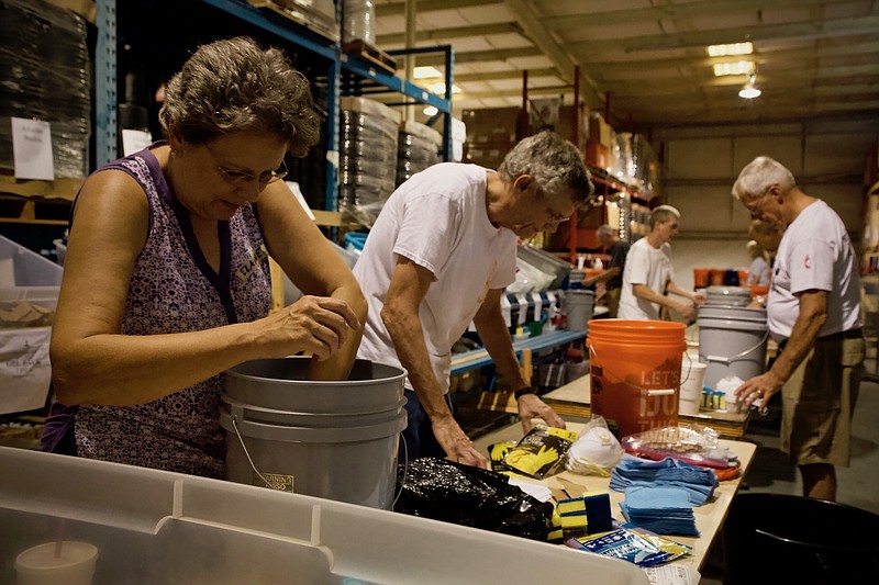 Elaine Edwards and Ross Moore, volunteers with Burks United Methodist Church, check cleaning supplies buckets at UMCOR's disaster relief warehouse in Decatur, Alabama on August 23.