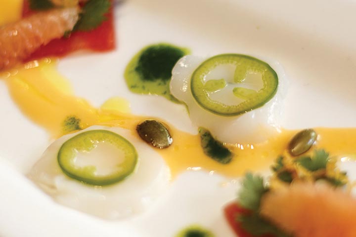 Staff photo by C.B. Schmelter/ Chef Charlie Loomis's scallop crudo with cilantro oil, pickled jalapeÒos, compressed watermelon, grapefruit vinaigrette and pepitas at The Feed Table and Tavern on Wednesday, Aug. 7, 2019 in Chattanooga, Tenn.