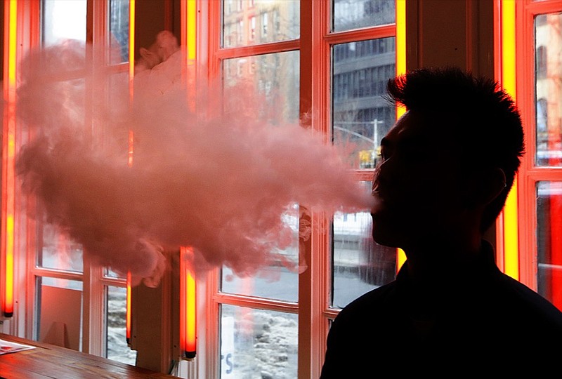 FILE - In this Feb. 20, 2014, File photo, a patron exhales vapor from an e-cigarette at the Henley Vaporium in New York. The first peek at a major study of how Americans smoke suggests many use combinations of products, and often e-cigarettes are part of the mix. It's a preliminary finding, but it highlights some key questions as health officials assess electronic cigarettes. (AP Photo/Frank Franklin II, File)