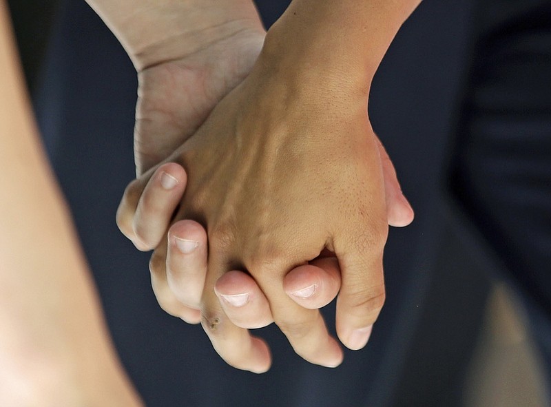 FILE - In this Wednesday, July 15, 2015 file photo, a lesbian couple holds hands in Salt Lake City. Released on Thursday, Aug. 29, 2019, the largest study of its kind found new evidence that genes contribute to same-sex sexual behavior, echoing research that says there is no single "gay gene." (AP Photo/Rick Bowmer)


