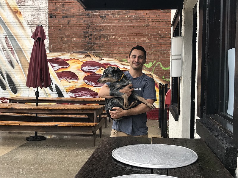 Staff photo by Emily Crisman / Southside Pizza co-owner and 4 Paws (Pantry) Palooza sponsor Eric Taslimi holds his dog Duke outside the restaurant.