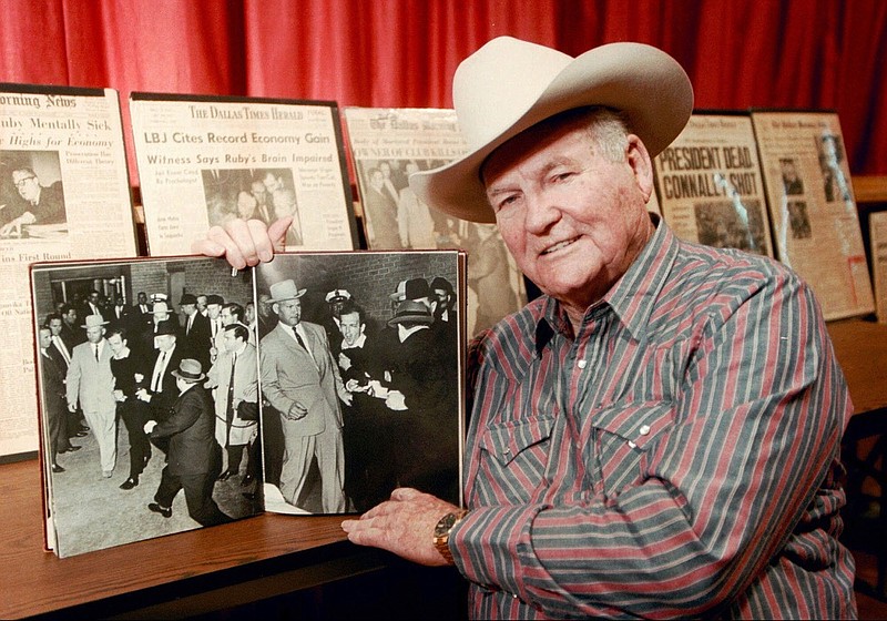 FILE - In this Dec. 11, 1998 file photo, shows Jim Leavelle in Stafford, Kansas holding the iconic 1963 photograph, as he escorted Lee Harvey Oswald moments before he is shot in Dallas. Leavelle, the longtime Dallas lawman has died, Thursday, Aug. 29, 2019. He was 99. (Sandra J. Milburn/The Hutchinson News via AP)


