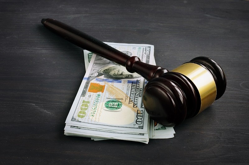 Gavel and money in the court. Penalty or bribe. money tile court jail bail bailout / Getty Images
 