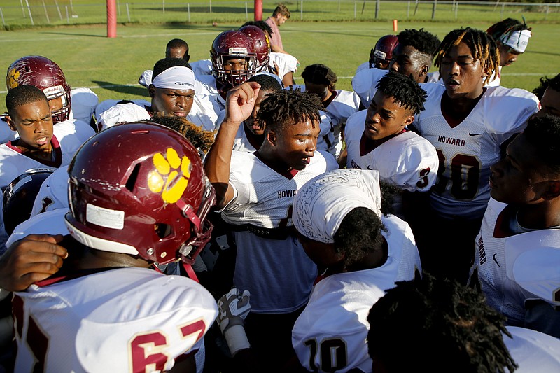 Staff photo by C.B. Schmelter / Howard football players huddle around teammate Eric Johnson, center, before their game against host Brainerd at Eddie Lambert Field on Friday night.