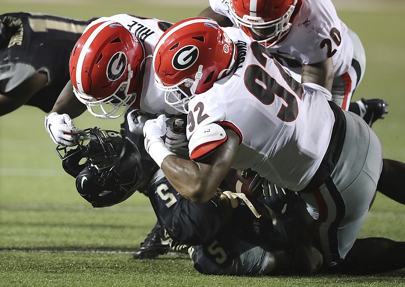Associated Press photo by Curtis Compton / Georgia defensive end Justin Young (92) rips the helmet off Vanderbilt running back Ke'Shawn Vaughn while making a tackle during the second quarter of Saturday night's game in Nashville. Young was called for a personal foul on the play.