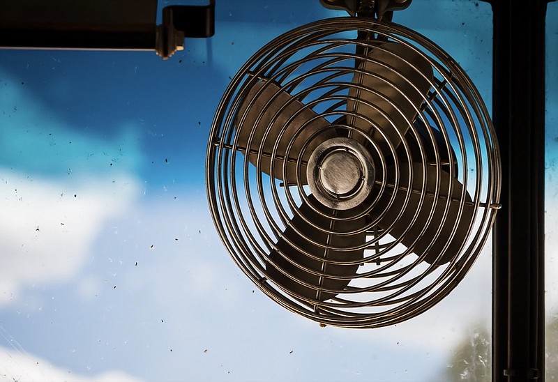 A classic fan in front of an old bus. A hot day with no air conditioning. fan tile school bus tile / Getty Images
