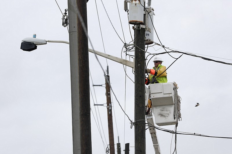 An electrical worker restores power along highway A1A as Hurricane Dorian made its way off the coast of Ormond-by-the-Sea, Fla., Wednesday, Sept. 4, 2019. (AP Photo/John Raoux)