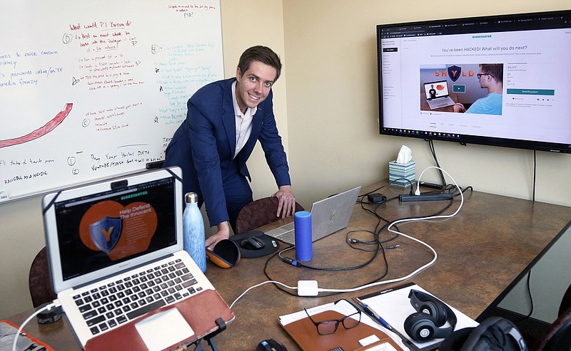 In this Aug. 27, 2019 photo, Tyler Olson poses in his office at the University of St. Thomas - Minneapolis campus. Olson is just starting a cybersecurity company. (AP Photo/Jim Mone)
