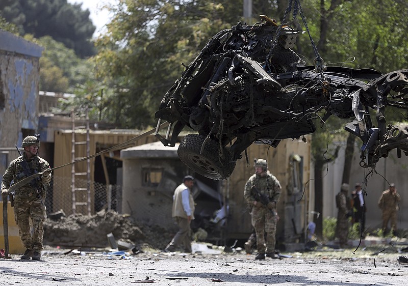 Resolute Support (RS) forces remove a damaged vehicle after a car bomb explosion in Kabul, Afghanistan, Thursday, Sept. 5, 2019. A car bomb rocked the Afghan capital on Thursday and smoke rose from a part of eastern Kabul near a neighborhood housing the U.S. Embassy, the NATO Resolute Support mission and other diplomatic missions. (AP Photo/Rahmat Gul)