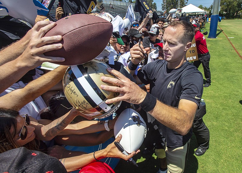 The Associated Press / New Orleans Saints quarterback Drew Brees signs autographs for fans following a joint NFL football practice with the Los Angeles Chargers in Costa Mesa, Calif., last month.