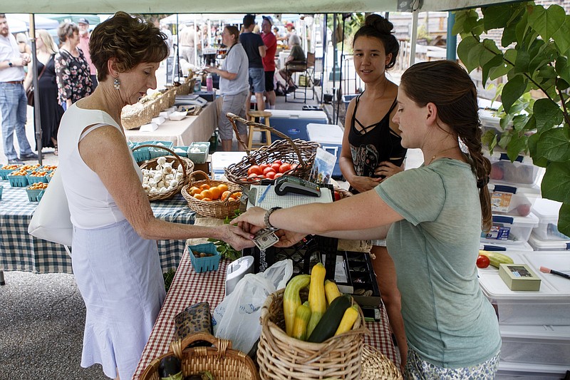 Staff photo by C.B. Schmelter/ Veda Bucher, left, gets her change from Courtney Parker at the Crabtree Farms tent.