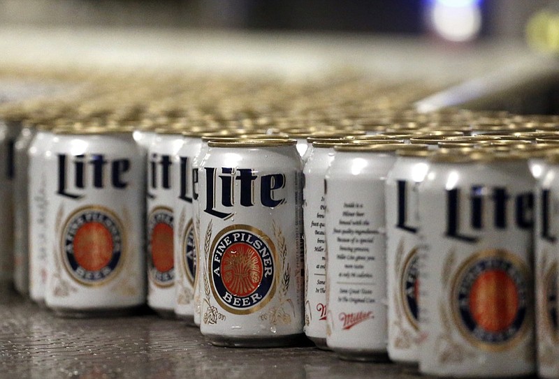 FILE - In this March 11, 2015 file photo, newly-filled and sealed cans of Miller Lite beer move along on a conveyor belt, at the MillerCoors Brewery, in Golden, Colo. A federal judge has ordered Anheuser-Busch to stop using packaging that implies MillerCoors' light beers contain corn syrup. U.S. District Judge William Conley granted a preliminary injunction sought by MillerCoors. Bud Light's packaging says "No Corn Syrup" in bold letters. (AP Photo/Brennan Linsley, File)


