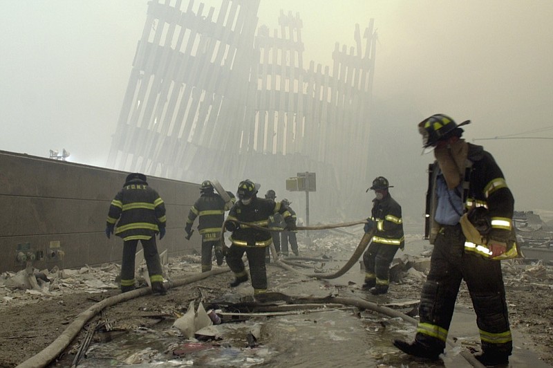 FILE - In this Sept. 11, 2001 file photo, firefighters work beneath the destroyed mullions, the vertical struts which once faced the outer walls of the World Trade Center towers, after a terrorist attack on the twin towers in New York. New research released on Friday, Sept. 6, 2019 suggests firefighters who arrived early or spent more time at the World Trade Center site after the 9/11 attacks seem to have a greater risk of developing heart problems than those who came later and stayed less. (AP Photo/Mark Lennihan)


