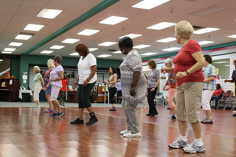 Attendees participate in line dancing at the Eastgate Senior and Activity Center on Friday. Experts say maintaining meaningful connections and activities are good practices to guard against mood disorders that are more prevalent with age.

Photo by Elizabeth Fite/Times Free Press