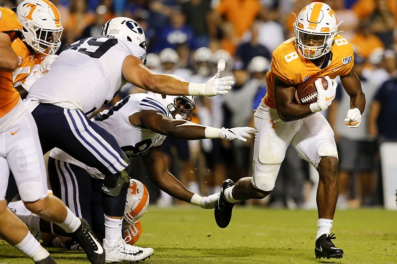Staff photo by C.B. Schmelter / BYU defenders reach for Tennessee running back Ty Chandler during Saturday night's game at Neyland Stadium.