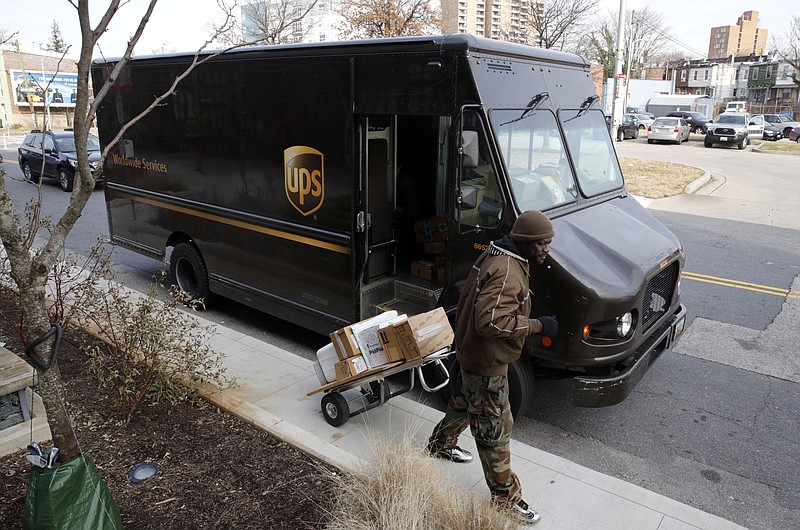 FILE - In this Dec. 19, 2018, file photo a UPS driver prepares to deliver packages in Baltimore. UPS said Monday, Sept. 9, 2019, that it expects to hire about 100,000 seasonal workers and pay them more to handle the avalanche of packages shipped between Thanksgiving and Christmas. (AP Photo/Patrick Semansky, File)