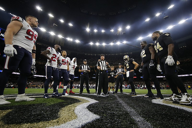 The referee performs the coin toss before an NFL football game between the New Orleans Saints and the Houston Texans in New Orleans, Monday, Sept. 9, 2019. (AP Photo/Gerald Herbert)
