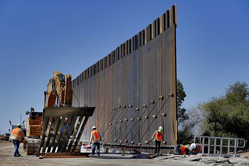 Government contractors erect a section of Pentagon-funded border wall along the Colorado River, Tuesday, Sept. 10, 2019 in Yuma, Ariz. The 30-foot high wall replaces a five-mile section of Normandy barrier and post-n-beam fencing along the the International border that separates Mexico and the United States. Construction began as federal officials revealed a list of Defense Department projects to be cut to pay for President Donald Trump's wall. (AP Photo/Matt York)