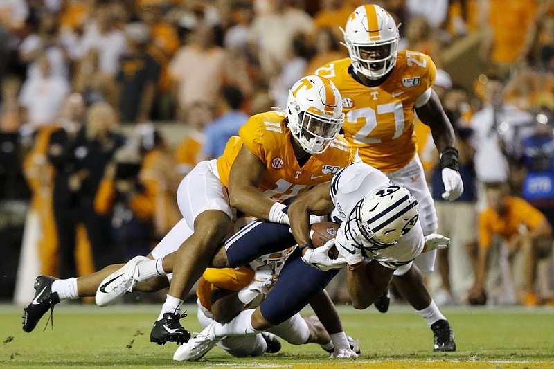 Staff photo by C.B. Schmelter / Tennessee linebacker Henry To'o To'o (11) and defensive back Shawn Shamburger, obscured, work to tackle BYU wide receiver Micah Simon during last Saturday's game at Neyland Stadium.