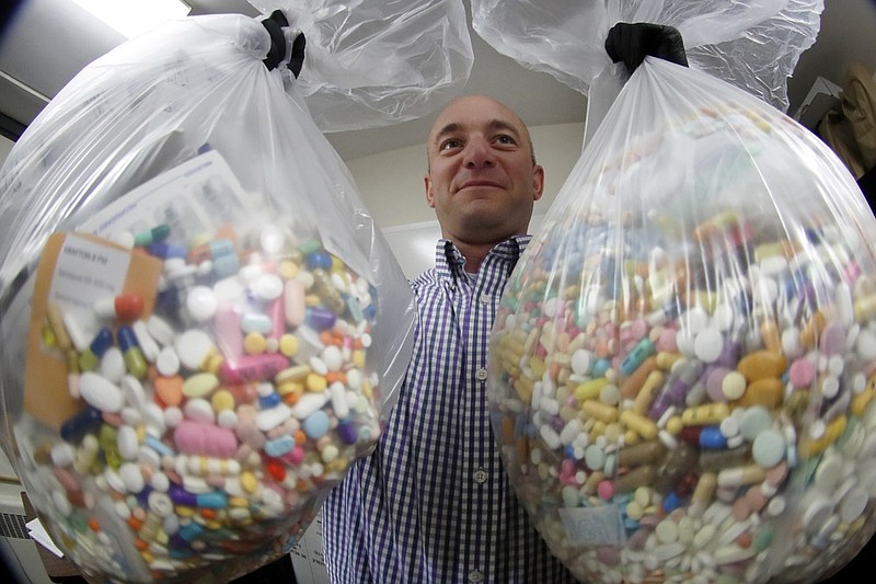 Narcotics detective Ben Hill, with the Barberton Police Department, shows two bags of medications that are are stored in their headquarters and slated for destruction, Wednesday, Sept. 11, 2019, in Barberton, Ohio. Attorneys representing some 2,000 local governments said Wednesday they have agreed to a tentative settlement with OxyContin maker Purdue Pharma over the toll of the nation's opioid crisis. (AP Photo/Keith Srakocic)


