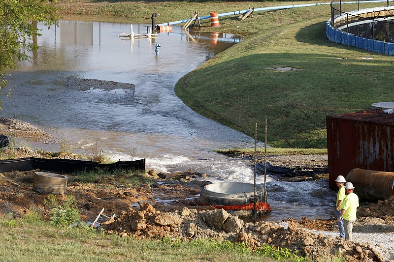  Staff photo by C.B. Schmelter / Workers are seen as water floods by a tank on the Tennessee River on Friday, Sept. 13, 2019 in Chattanooga, Tenn. Tennessee American Water is working to repair a water main break that happened Thursday evening near its plant on Wiehl Street.