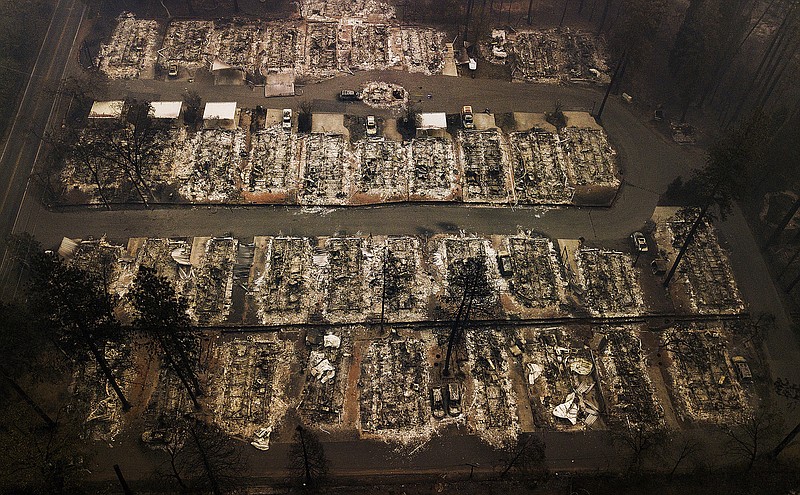 FILE - This Nov. 15, 2018, aerial file photo shows the remains of residences leveled by the Camp wildfire in Paradise, Calif. Pacific Gas & Electric and a group of insurers say they have reached an $11 billion settlement to cover most of the claims from the 2017 and 2018 wildfires in California. The utility said in a statement Friday, Sept. 13, that the tentative agreement covers 85% of the insurance claims, including a fire that decimated the town of Paradise. (AP Photo/Noah Berger, File)