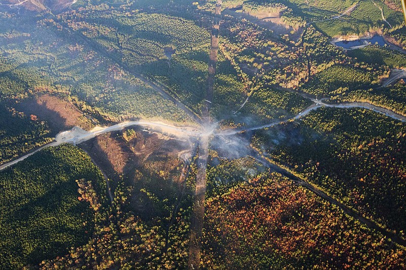 FILE - In this Nov. 1, 2016 file photo, a fog of smoke covers the trees near an explosion of a Colonial Pipeline  in Helena, Ala.  A new federal lawsuit accuses a pipeline company of failing to tell work crews where a major U.S. pipeline was underground before they ruptured the line, touching off a deadly explosion. The estate of Anthony Willingham, an Alabama worker who died in the blast, this week filed a federal lawsuit against Georgia-based Colonial Pipeline Co. and a partner company. (AP Photo/Brynn Anderson, File)