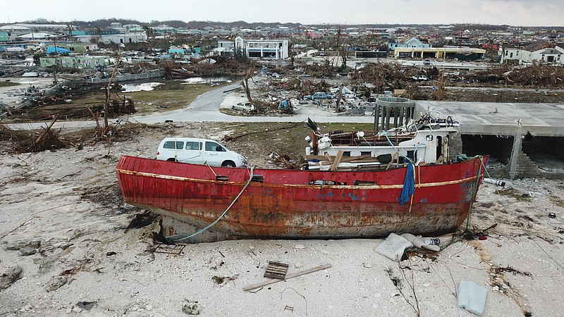 In this Sept. 6, 2019, photo, a boat sits grounded in the aftermath of Hurricane Dorian, in Marsh Harbor, Abaco Island, Bahamas. The Bahamian health ministry said helicopters and boats are on the way to help people in affected areas, though officials warned of delays because of severe flooding and limited access. (AP Photo/Gonzalo Gaudenzi)