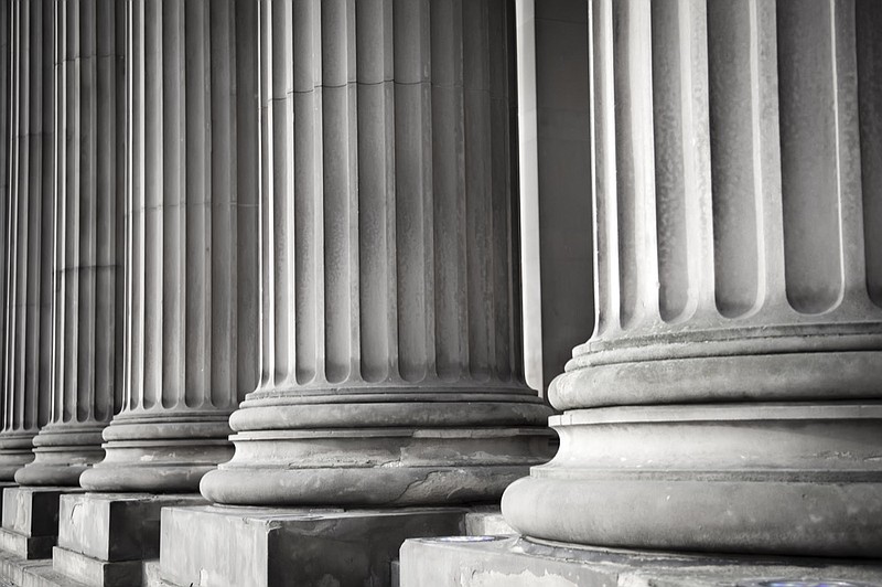 Row of columns in black and white court tile warrant justice judicial executive legislation tile building / Getty Images
