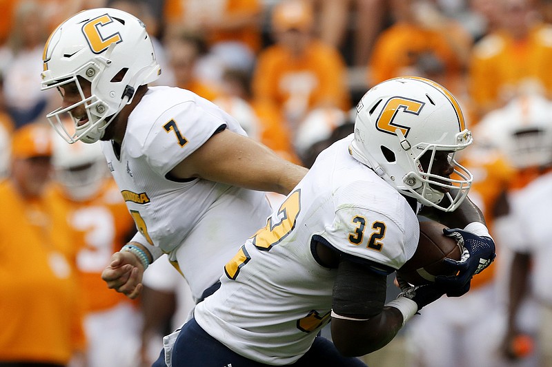 Staff photo by C.B. Schmelter / UTC quarterback Nick Tiano (7) hands the ball off to running back Ailym Ford (32) agaisnt Tennessee during a NCAA football game at Neyland Stadium on Saturday, Sept. 14, 2019 in Knoxville, Tenn.