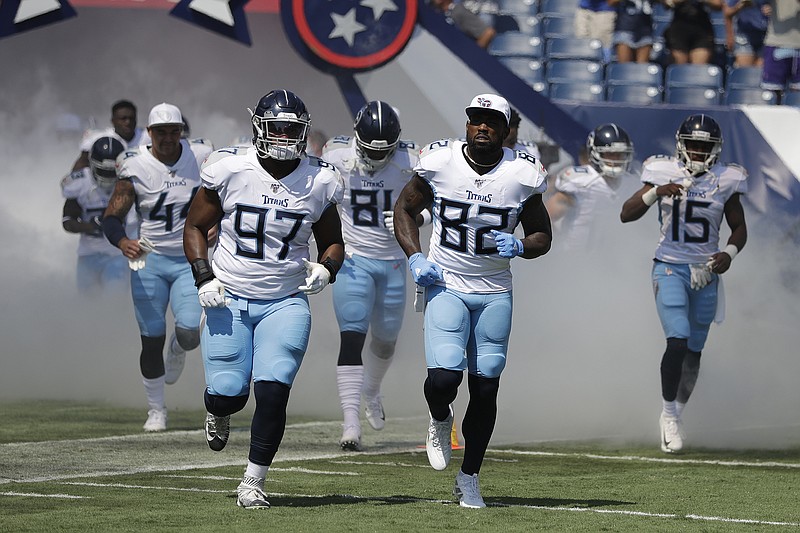 Associated Press photo by James Kenney / The Tennessee Titans, including defensive tackle Isaiah Mack (97) and tight end Delanie Walker (82), take the field for Sunday's home and AFC South opener against the Indianapolis Colts.