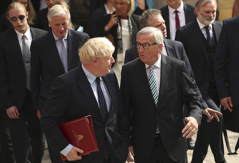 European Commission President Jean-Claude Juncker, center right, and British Prime Minister Boris Johnson, center left, leave a restaurant after a meeting in Luxembourg, Monday, Sept. 16, 2019. British Prime Minister Boris Johnson was holding his first meeting with European Commission President Jean-Claude Juncker on Monday in search of a longshot Brexit deal. (AP Photo/Francisco Seco, Pool)