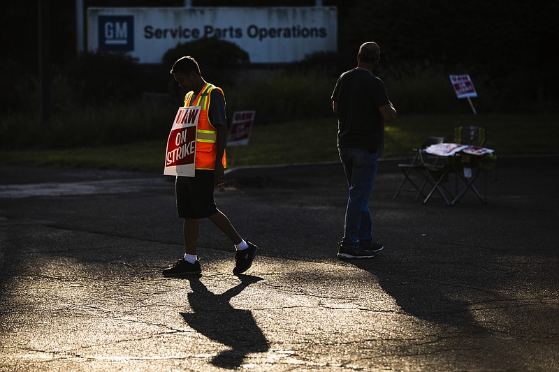 Workers Joel Inocencio, left, and Mike Jones demonstrative outside a General Motors facility in Langhorne, Pa., Tuesday, Sept. 17, 2019. More than 49,000 members of the United Auto Workers walked off General Motors factory floors or set up picket lines early Monday as contract talks with the company deteriorated into a strike. (AP Photo/Matt Rourke)