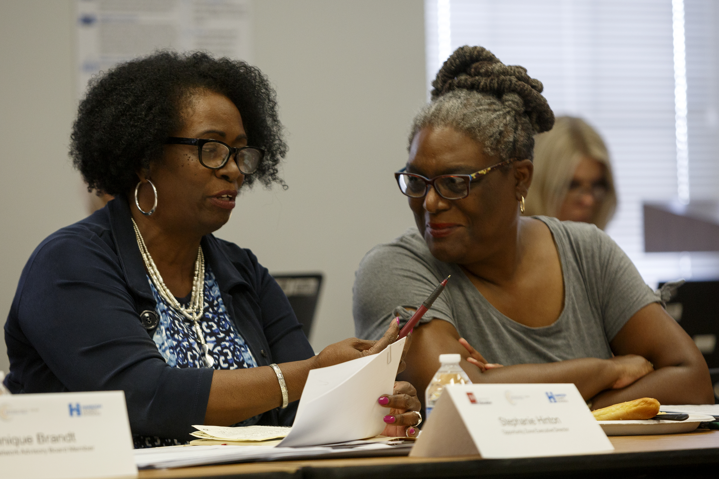 Staff photo by C.B. Schmelter / Opportunity Zone Executive Director Stephanie Hinton, left, explains an acronym to Partnership Network Advisory Board Member Ardena Garth and the rest of the people attending the Partnership Network Advisory board meeting at the Hamilton County Department of Education board room on Tuesday, Sept. 17, 2019 in Chattanooga, Tenn.