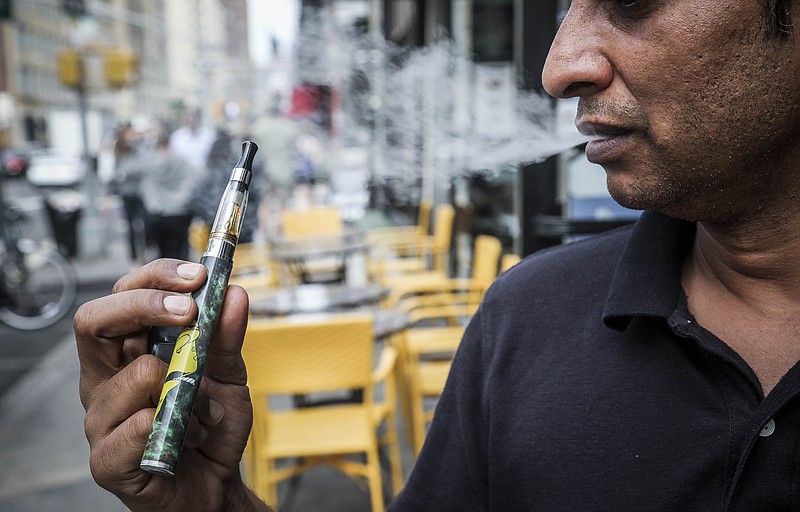 Inam Rehman, manager of Jubilee Vape & Smoke Inc., vapes while discussing New York Gov. Andrew Cuomo's push to enact a statewide ban on the sale of flavored e-cigarettes amid growing health concerns, Monday Sept. 16, 2019, in New York. (AP Photo/Bebeto Matthews)