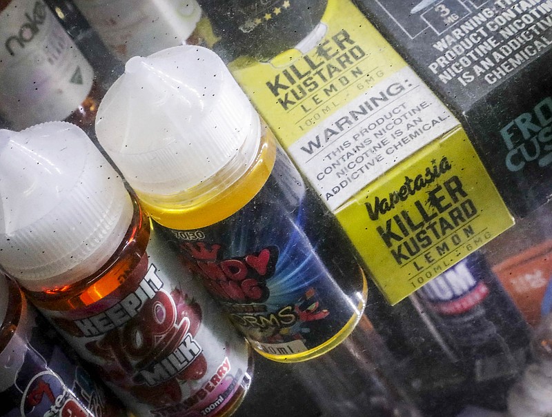 Flavored vaping solutions are shown in a window display at a vape and smoke shop, Monday Sept. 16, 2019, in New York. New York Gov. Andrew Cuomo is pushing to enact a statewide ban on the sale of flavored e-cigarettes amid growing health concerns of vaping. (AP Photo/Bebeto Matthews)