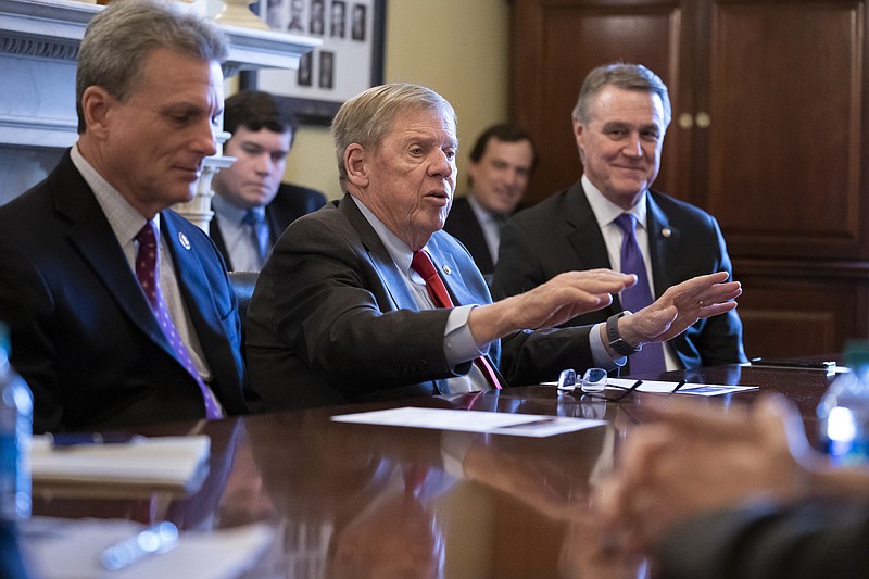 In this Feb. 14, 2019, file photo, Sen. Johnny Isakson, R-Ga., flanked by Rep. Buddy Carter R-Ga., left, and Sen. David Perdue, R-Ga., right, leads a meeting on Capitol Hill in Washington. Sen. Isakson announced on Wednesday, Aug. 28, 2019, that he will retire at the end of 2019, citing "health challenges." (AP Photo/J. Scott Applewhite, File)