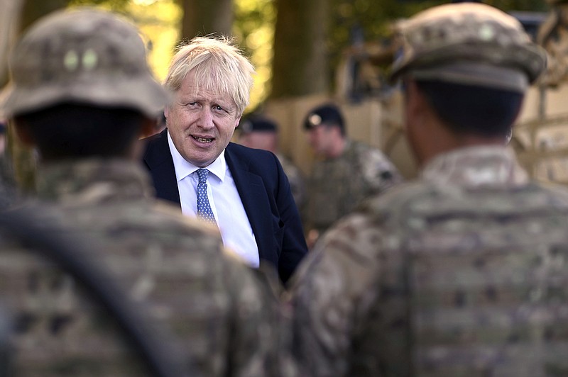 Britain's Prime Minister Boris Johnson talks to Ghurkas as he meets with military personnel on Salisbury Plain training area near Salisbury, England, Thursday, Sept. 19, 2019. British Prime Minister Boris Johnson was accused by a one of the country’s former leaders of a “conspicuous” failure to explain why he suspended Parliament for five weeks, as a landmark Brexit case at the U.K. Supreme Court came to a head on Thursday. (Ben Stansall/Pool Photo via AP)