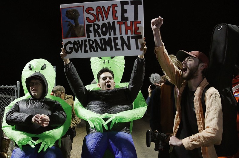 Mario Rayna, center, chants with others at an entrance to the Nevada Test and Training Range near Area 51 Friday, Sept. 20, 2019, near Rachel, Nev. People gathered at the gate inspired by the "Storm Area 51" internet hoax. (AP Photo/John Locher)