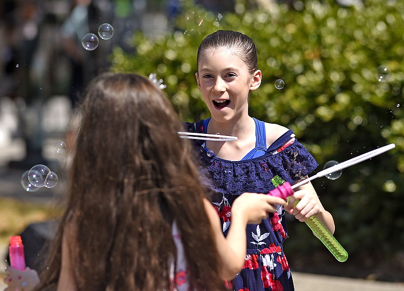 Staff Photo by Robin Rudd/  Tanith Parden, foreground, and Elise Giles blow bubbles at the St. Paul's Episcopal parking space.  Park(ing) day was hosted by the Chattanooga Design Studio on Broad Street on September 20, 2019.  The international event reclaims parking spaces as place for people.  