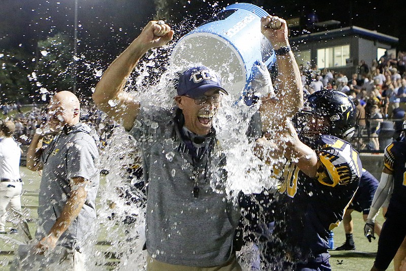 Staff photo by C.B. Schmelter / Chattanooga Christian football coach Mark Mariakis raises his arms in victory as he has water dumped on him after the Chargers beat Boyd Buchanan to win their homecoming game Friday night at David Stanton Field. 