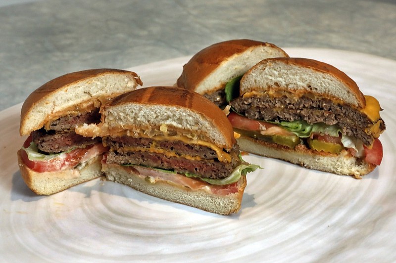 This Friday, May 3, 2019 file photo shows an Original Impossible Burger, left, and a Cali Burger, from Umami Burger, in New York. A new era of meat alternatives is here, with Beyond Meat becoming the first vegan meat company to go public and Impossible Burger popping up on menus around the country. Several new vegetarian products are competing to win over meat lovers, but two California companies _ Impossible Foods and Beyond Meat _ are grabbing attention for patties that are red before they're cooked, making them resemble raw beef. (AP Photo/Richard Drew)