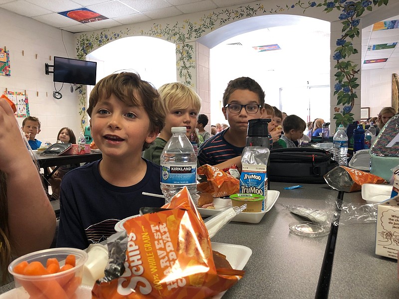 Second graders Toby Wolde, from left to right, Sam Zink and Tristan Yeargain, eat lunch in the cafeteria at Fairyland Elementary School on Monday morning.